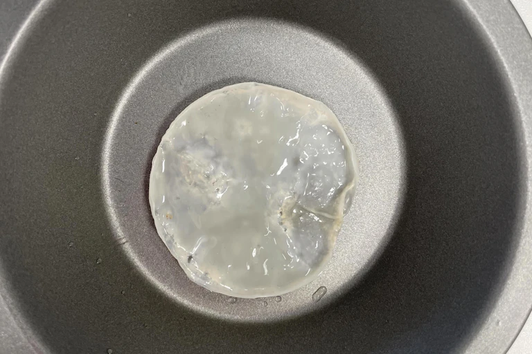A gelatinous white blob in a non stick grey bowl