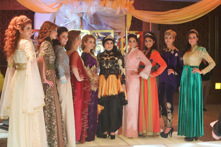 Some women modeling colorful abayas.