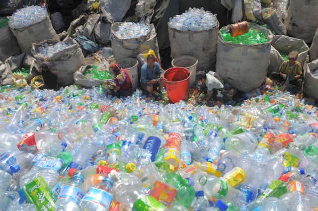 Homem chinês em meio a toneladas de garrafas plásticas