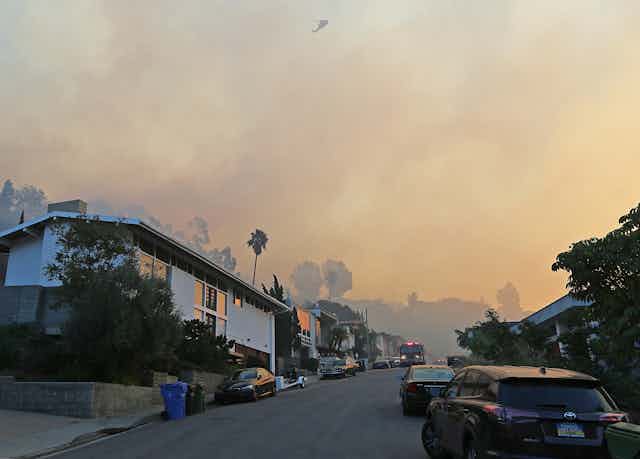 Smoke wafts over a residential street as a wildfire threatens part of Los Angeles on Dec. 6, 2017.
