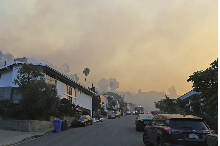 Smoke wafts over a residential street as a wildfire threatens part of Los Angeles on Dec. 6, 2017.