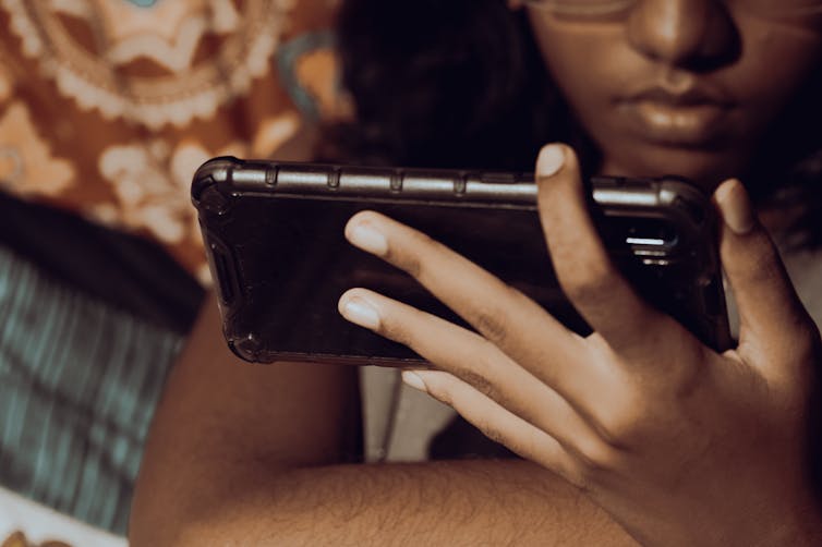 A youth seen holding a smartphone.