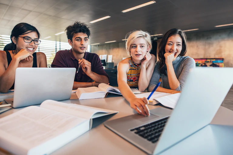 Young people seen in front of a laptop.