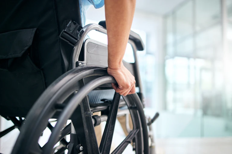 A close up on a hand on a wheelchair.