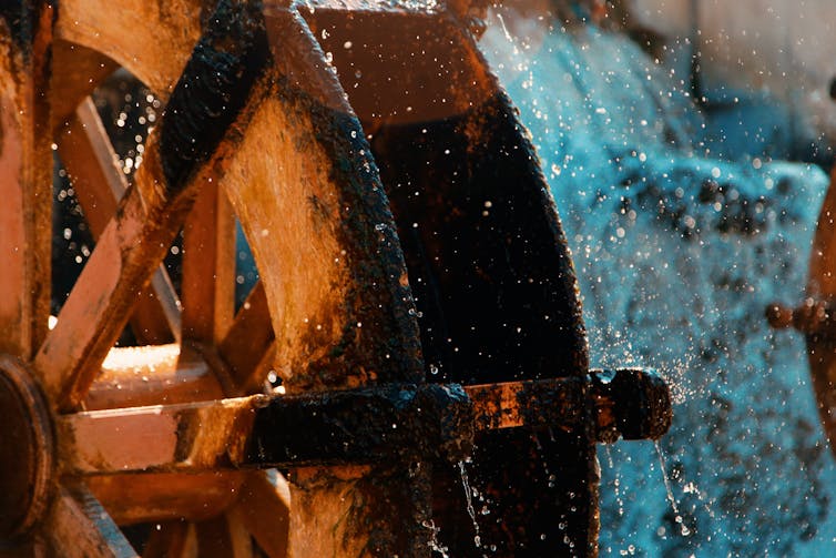 A wooden water wheel turning.
