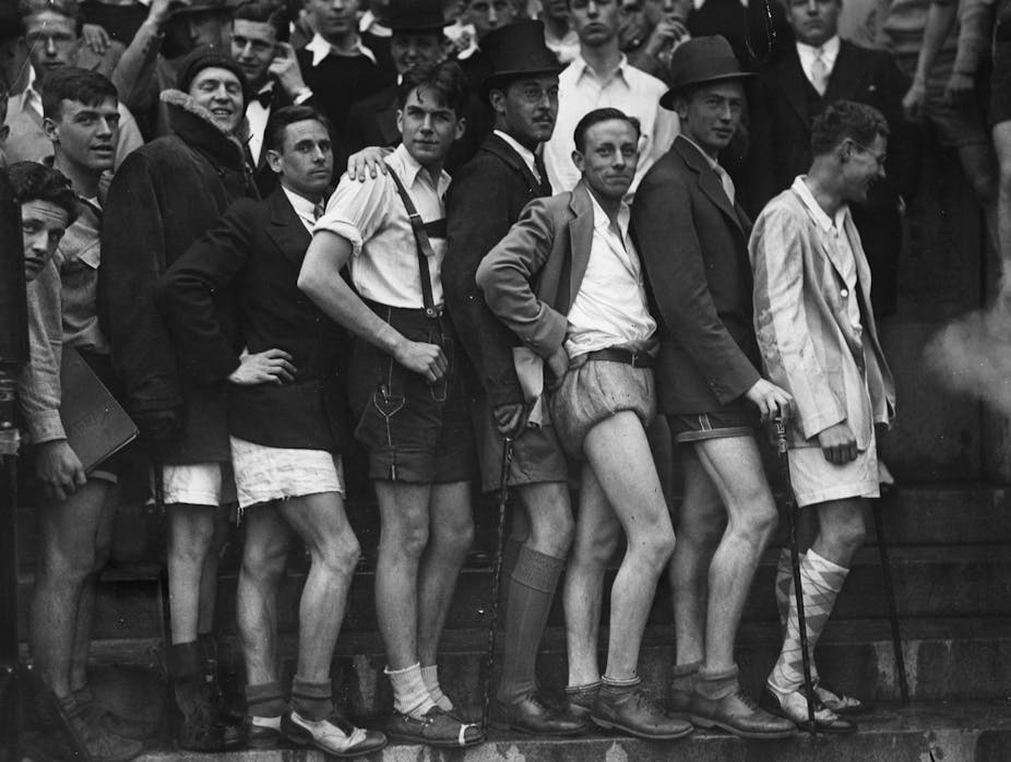 Black and white photo of young men posing wearing shorts.
