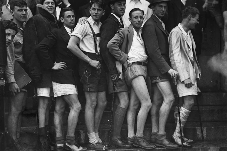 Black and white photo of young men posing wearing shorts.