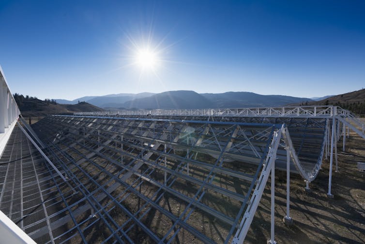 A photo showing an array of radio antennas beneath a sunny sky.