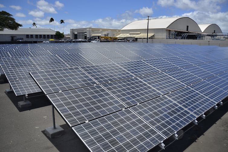 Solar panels outside a military airplane hangar.