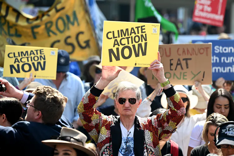 Man holding 'climate action now' poster