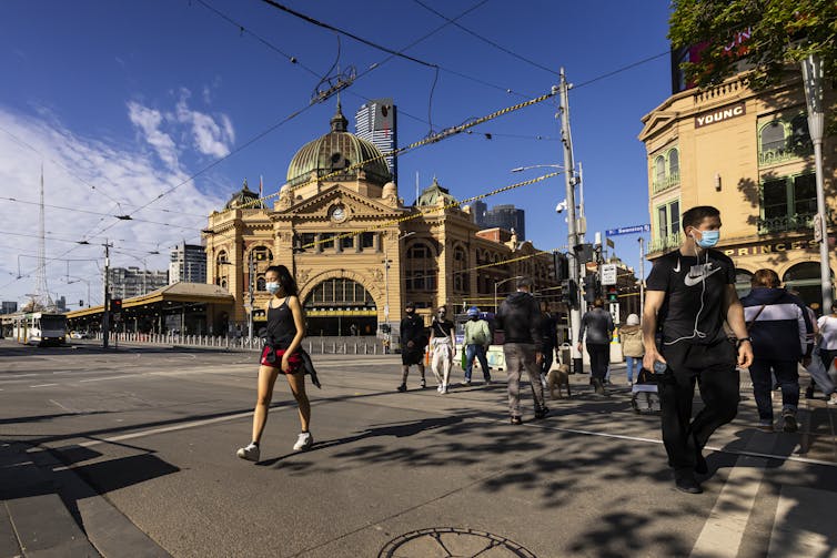 Flinders Street Station and people in masks