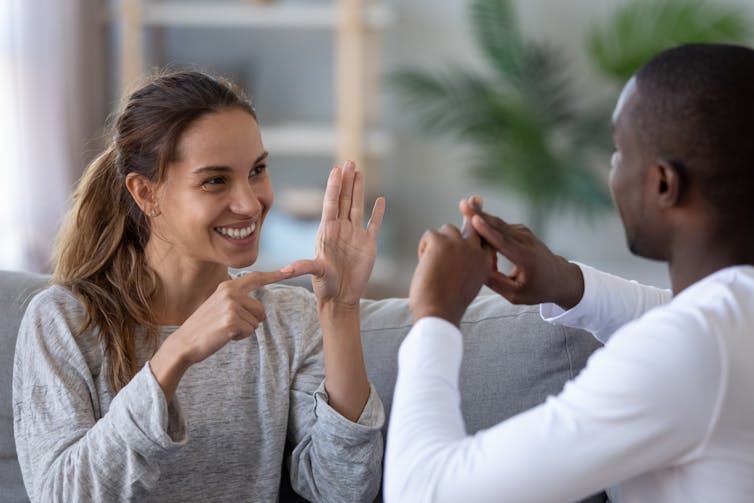 A man and a woman using sign language to communicate