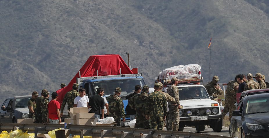 SOldiersSoldiers inspect lorries and cars as ethnic Armenians flee across the border from Azerbaijan inspect lorries and cars as Armenians corss the border from Azerbaijan