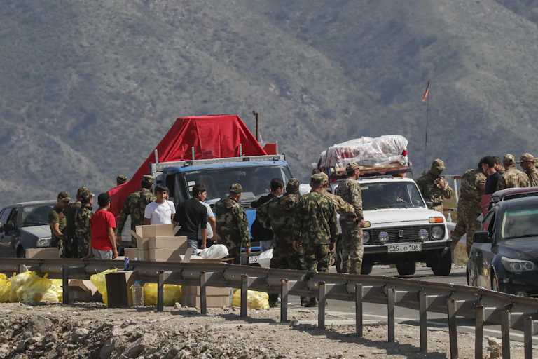 SOldiersSoldiers inspect lorries and cars as ethnic Armenians flee across the border from Azerbaijan inspect lorries and cars as Armenians corss the border from Azerbaijan