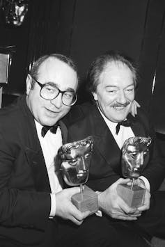 Bob Hoskins puts his arm around Michael Gambon, both wearing tuxedos and holding Bafta awards.