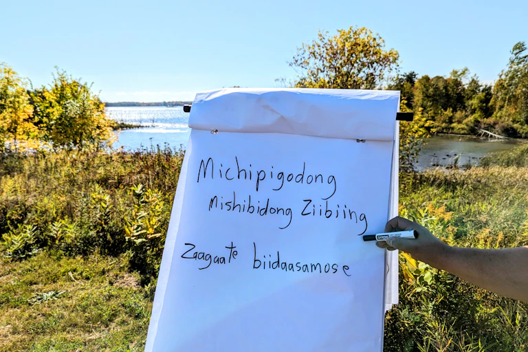 Traditional language written on paper and a river in the background.