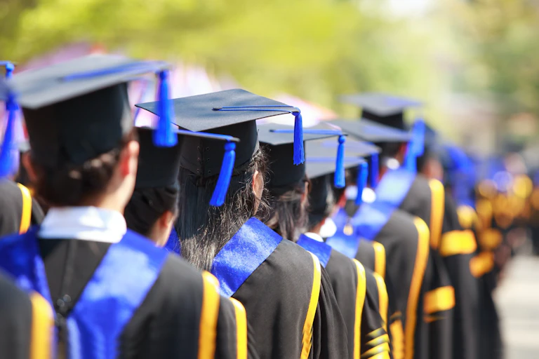 A row of university graduates wearing mortar boards and gown