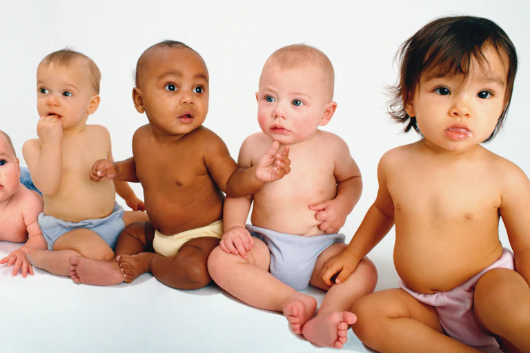 Babies sitting together look in different directions.