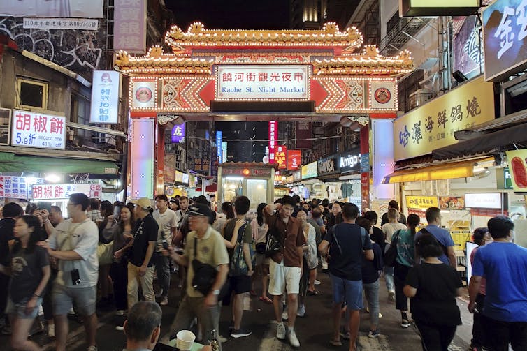 A crowd of people gathers in a public area.