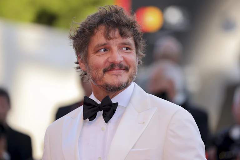 A man in a white tuxedo posing for a photo.