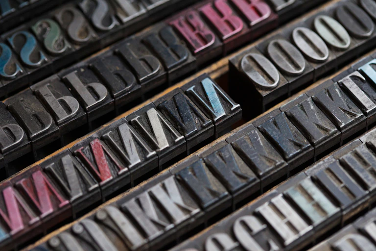 Vintage metal printing press letters are seen in close-up.