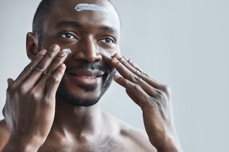 Man puts sunscreen on his face