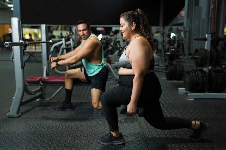 A woman does lunges in the gym.