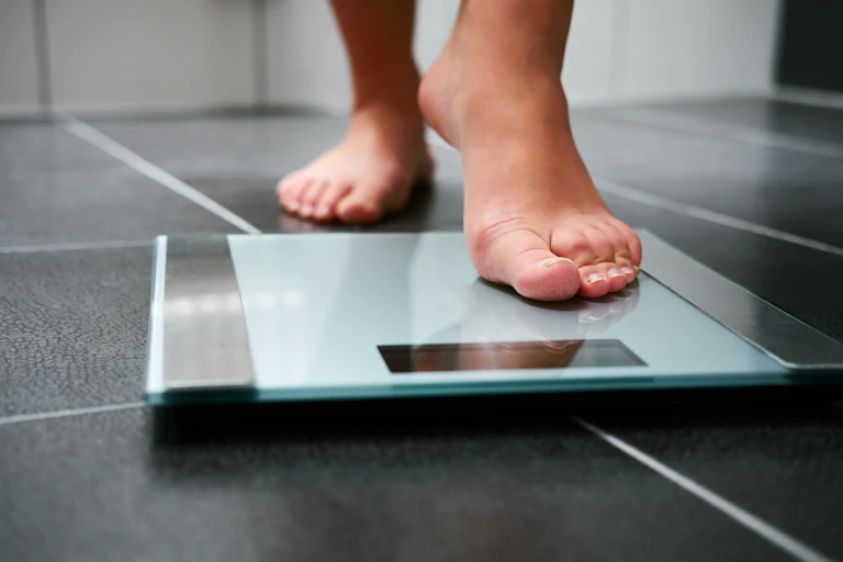 Person steps onto bathroom scales