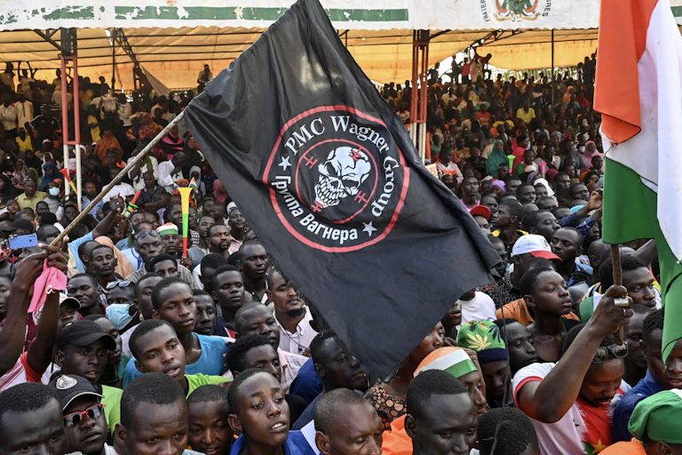 A crowd of people waving flags