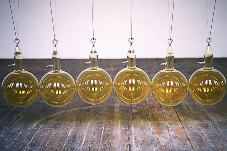 Des boules de verre soufflé sont supsendues dans une salle d'exposition.
