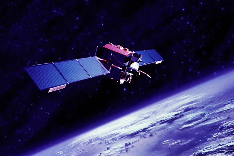 A satellite floats in space while the Earth can be seen in the background.