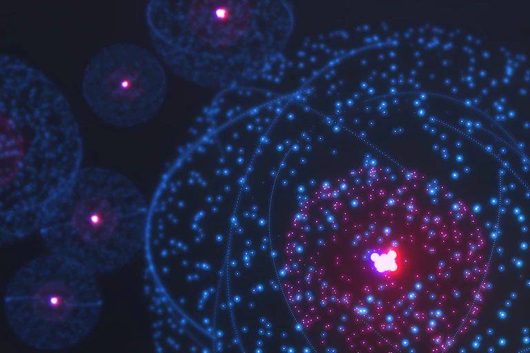 An illustration of atoms, depicted as pinpricks of light arranged in a sphere, brighter in the center, against a dark background.
