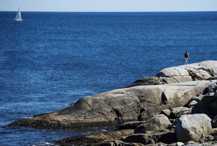 A rocky shoreline against a blue ocean.