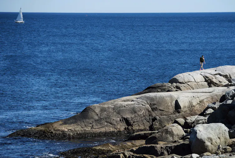 A rocky shoreline against a blue ocean.