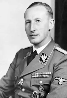 A white man with blonde hair and dressed in a military uniform poses for a photograph.