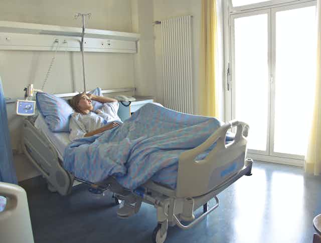 Woman lays in hospital bed