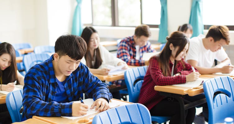 Chinese students in a classroom taking notes