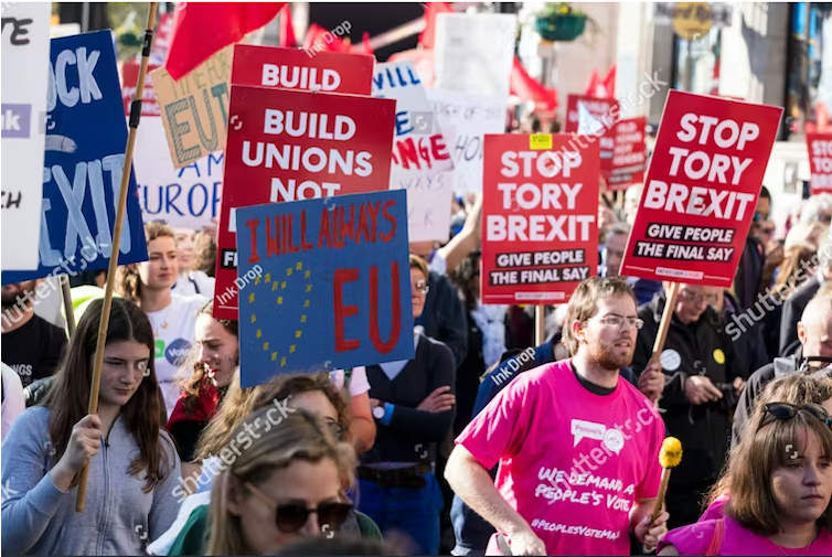 Large group of people carrying placards protesting against Brexit