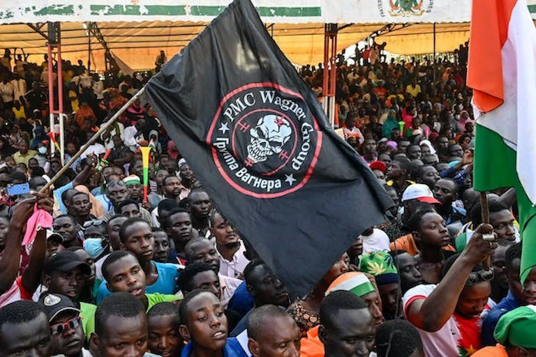 Une foule de personnes agitant des drapeaux
