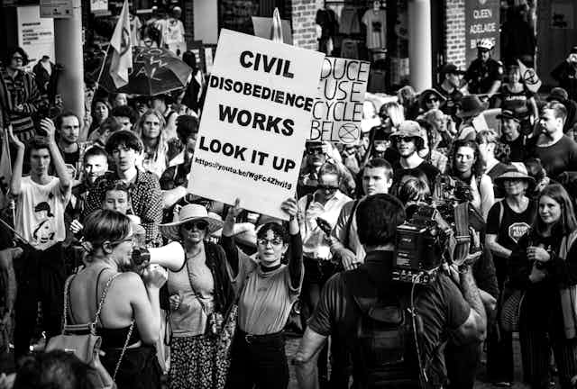 "La désobéissance civile marche " assure sur sa pancarte une militante australienne d'Extinction Rebellion lors d'une manifestation . 