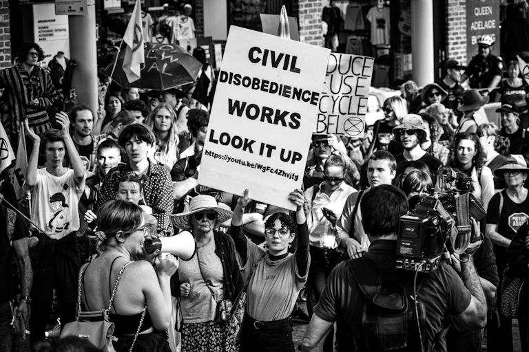 "La désobéissance civile marche " assure sur sa pancarte une militante australienne d'Extinction Rebellion lors d'une manifestation .