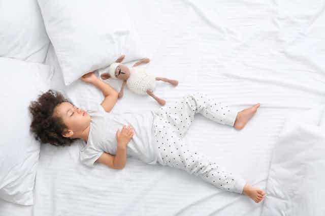 Child sleeping in large bed