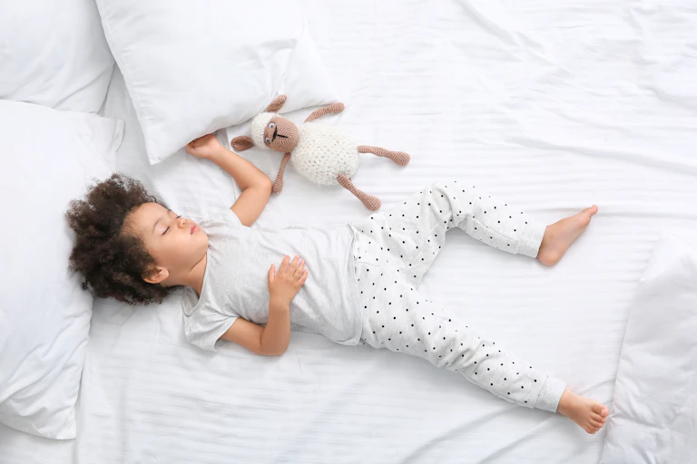 Child sleeping in large bed