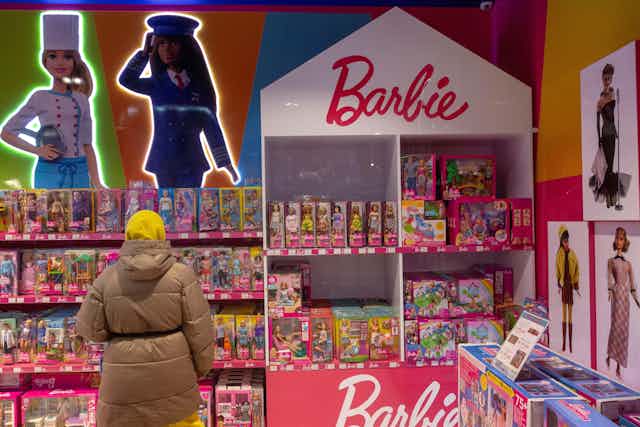 A woman looks at a display of Barbie dolls in a children's toy store in Moscow, Russia, in 2021.