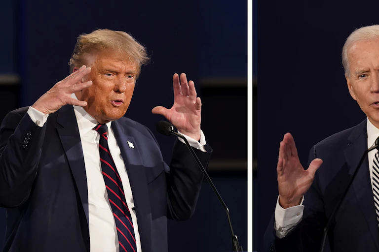 Two men in blue blazers and white shirts, gesturing with their hands.