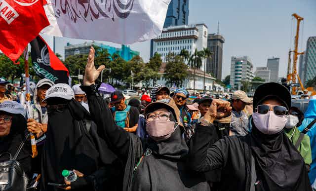 Masked people in a large protest.