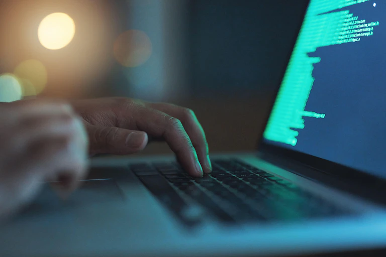 A hand in front of a keyboard.