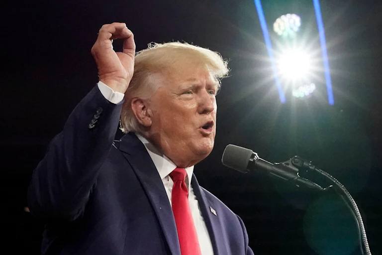 Donald Trump stands in front of a microphone.