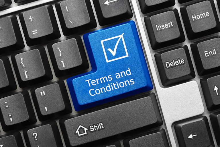 Computer keyboard with blue 'Terms and Conditions' key.