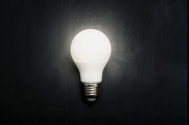 Foto de uma lâmpada brilhando sobre um fundo escuro